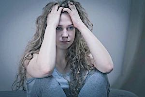 young woman holding head having bad thoughts