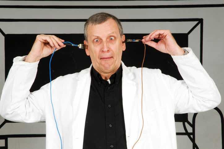 crazy man inserting forks with wires in both ears