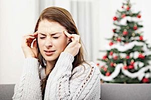 stressed woman holding head with pained look