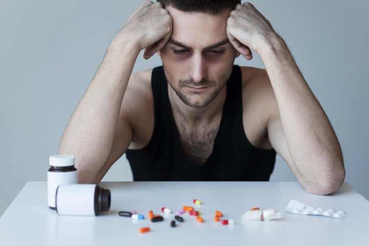 man looking at and thinking about pills