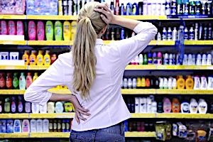 woman can't decide among choices of products on shelves