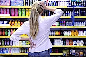 woman can't decide among choices of products on shelves