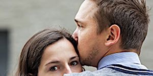 apprehensive man and woman holding each other closely