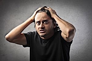 man grabbing his head in frustration
