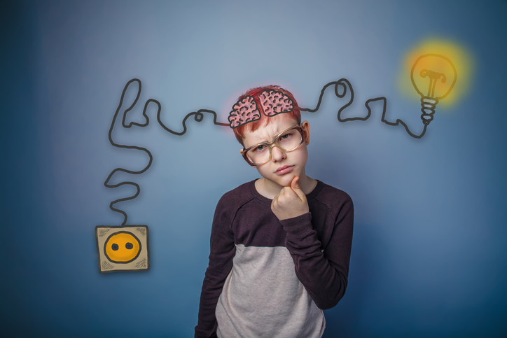 young boy at school thinking hard about a problem