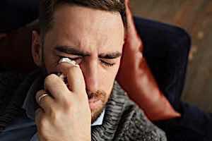 man crying wiping eyes with handkerchief