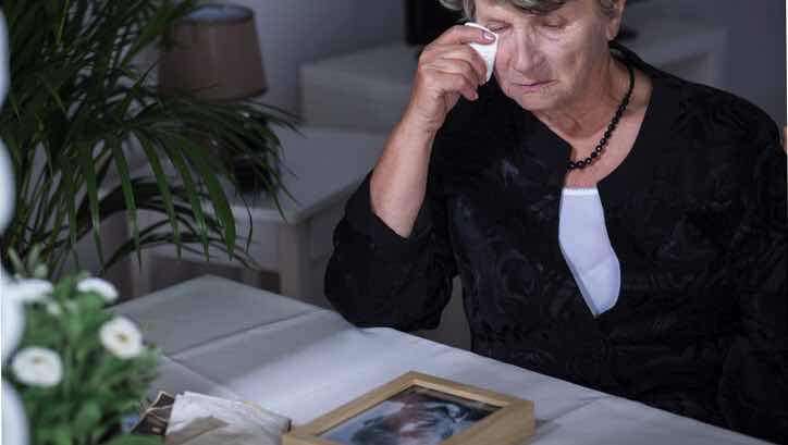 sad woman looking at photo of deceased husband