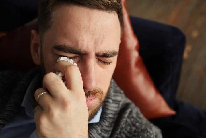 man crying sad tears with handkerchief after arguing romance