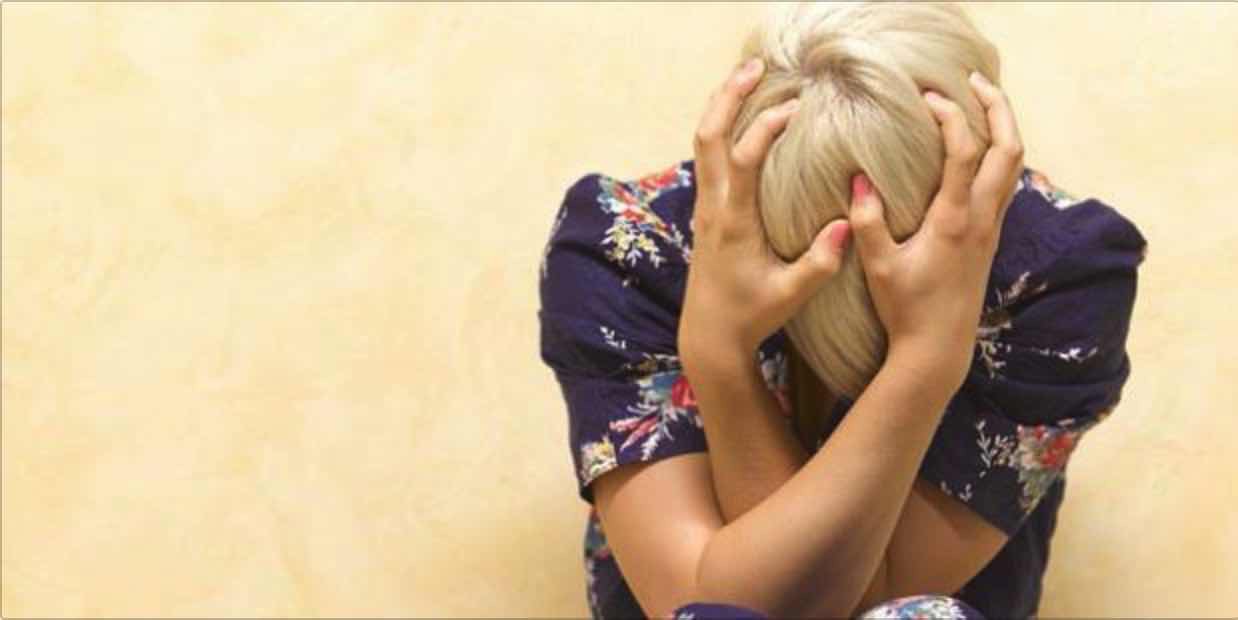 woman clasping her head in emotional turmoil