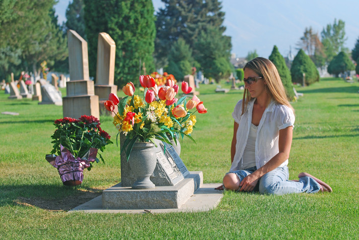 woman kneeling at gravesite