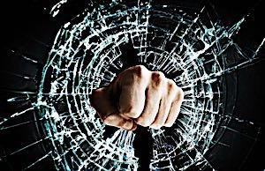 angry man using fist to break glass