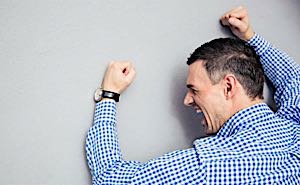 angry man banging against wall