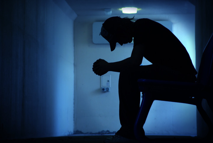depressed man sitting in the dark