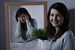 woman smiling with mirror reflecting her in despair