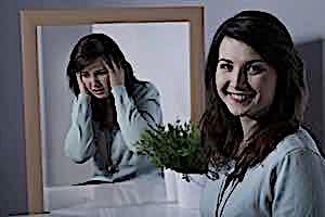 woman smiling with mirror reflecting her in despair