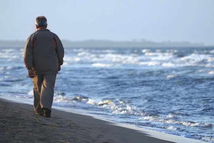 depressed man walking alone at the beach