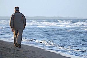 depressed man walking alone at the beach