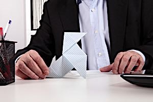 business man wasting time by playing with paper