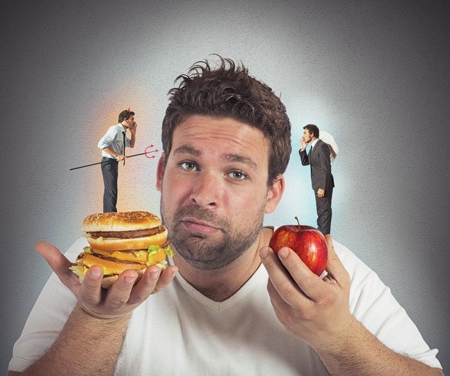 man deciding between eating apple or hamburger