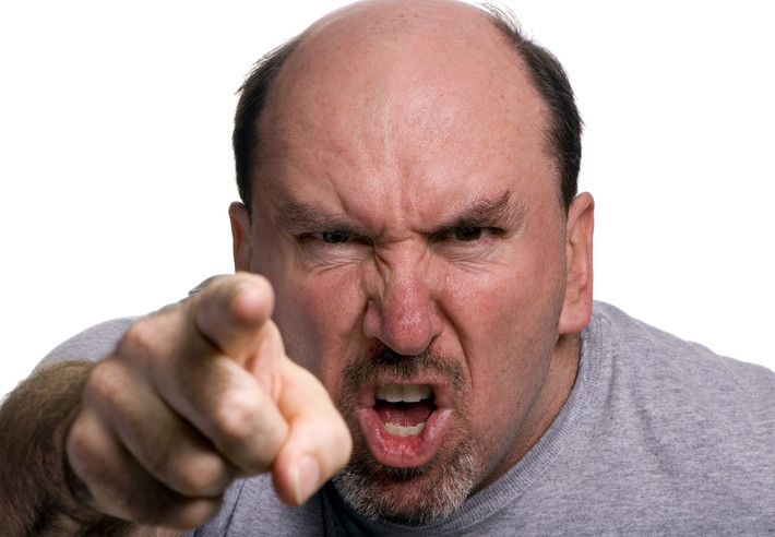 Angry man wags finger giving orders