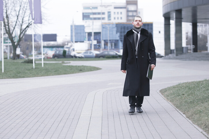 Unemployed businessman walking with resume