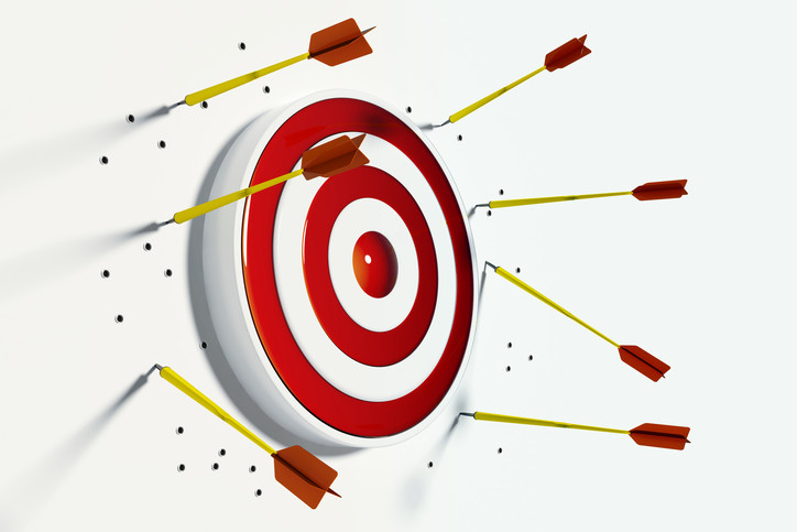 archery target surrounded by arrows all missing target