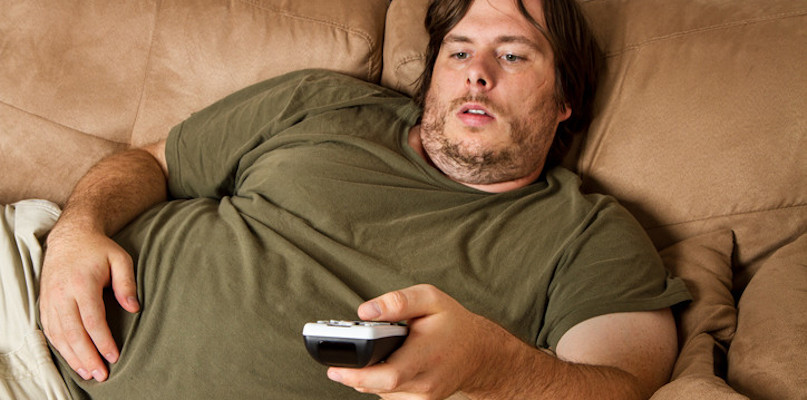 obese man on couch with tv remote control