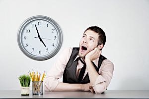 bored worker yawning and staring at clock