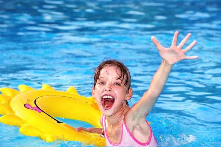 girl in pool inflatable float happy waving