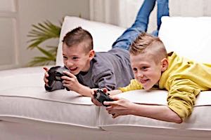 two happy smiling boys playing video games