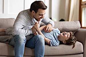 Dad tickling child on chest