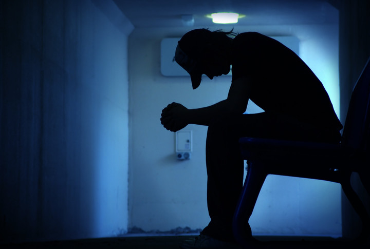 depressesd boy isolated in a dark room
