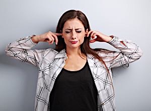 girl plugs ears with fingers to avoid hearing mom.