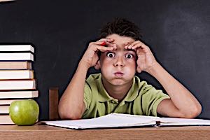 defiant boy makes faces at teacher