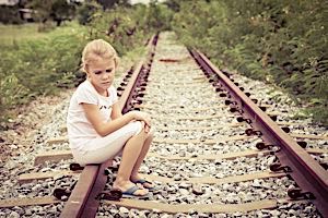 lonely sad girl sitting on railroad tracks
