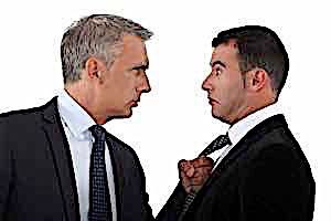 man agressively grabs tie of another man