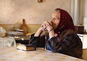 Old woman praying with bible