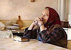 Old woman praying with bible