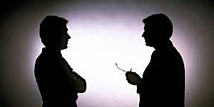 man talking with another man with crossed arms