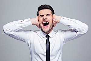 man covers ears with hands to block out noise