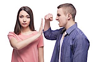 woman holds up hand to stop man with clenched fist