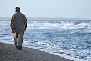lonely man walking on beach