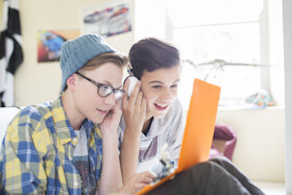 two young teens staring at computer screen
