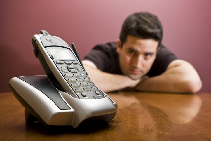 man waits by phone that does not ring