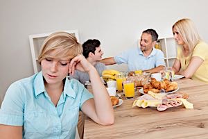 woman at table is ignored by happy table mates