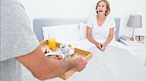 man bring woman breakfast in bed