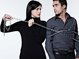 woman forcing a man to stay with her by wraping him in chains