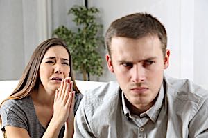 woman crying begs forgiveness from angry man