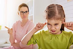 girl puts fingers in her ears while mom nags and yells