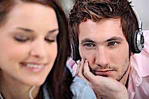 man wearing headphones gazing admiringly at smiling woman